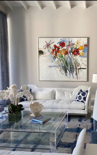 White sofa with floral art on a blue and white rug