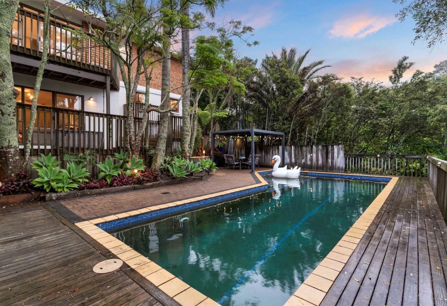 Backyard pool area with a inflatable swan and dining gazebo.