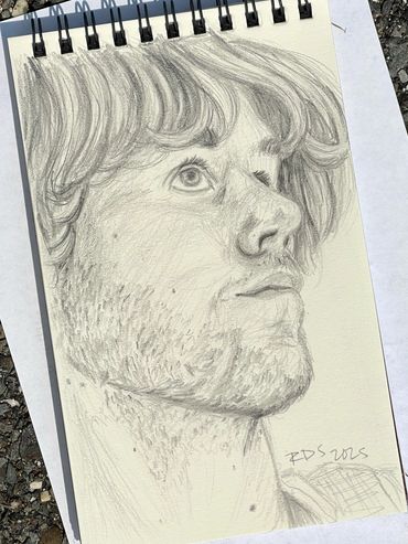 Pencil drawing of a man's face looking to the top right corner of the drawing.