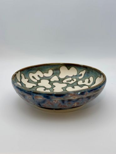 Decorative shallow ceramic bowl with abstract patterns.