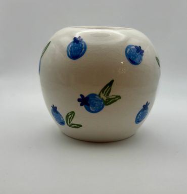 White ceramic vase with blue fruit designs.