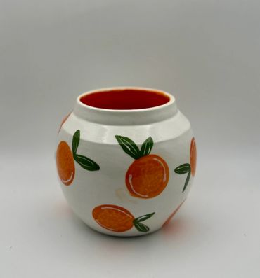 White ceramic pot with orange fruit designs.