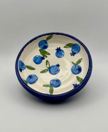 Hand-painted bowl with blue fruit design.