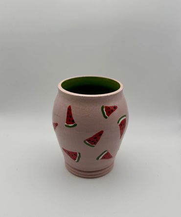Pink ceramic vase with watermelon designs.
