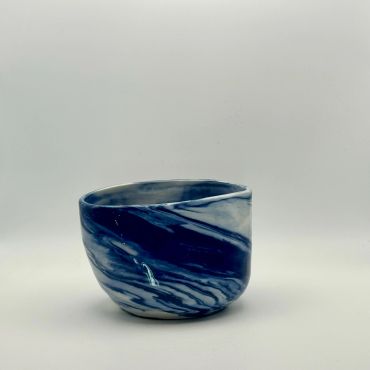 Blue and white ceramic cup with a wavy pattern.