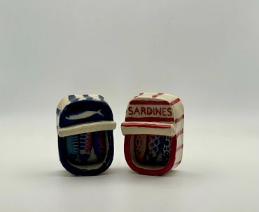 Two miniature sardine tins with lids open.