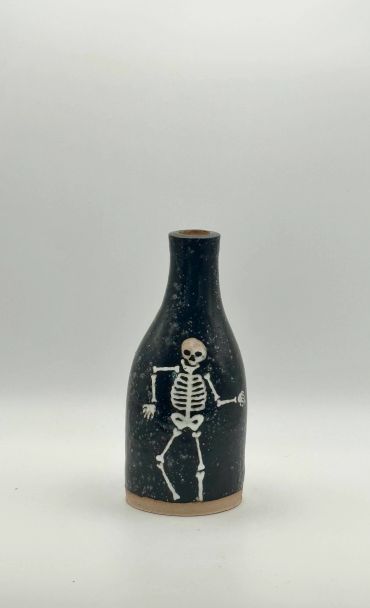 Black ceramic vase with skeleton design.