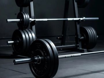 Barbells with weight plates in a gym.