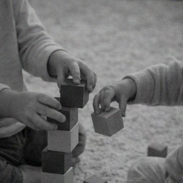 Two children stacking wooden blocks.