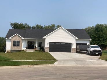Modern single-story house with a large garage and front lawn.