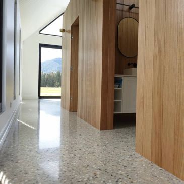 Modern hallway with terrazzo flooring and wooden walls.