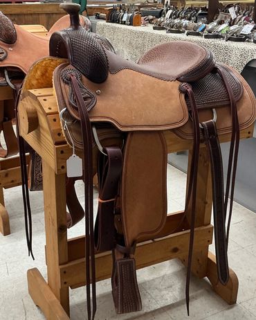 Leather Western saddle on a wooden stand.