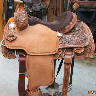 Handcrafted leather horse saddle with detailed carvings.