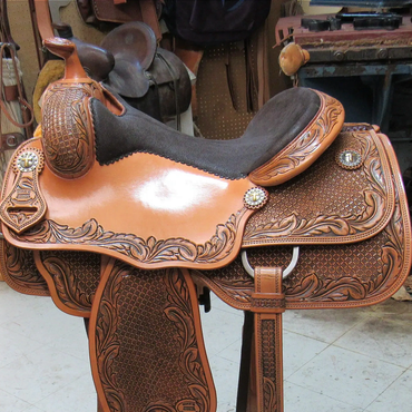 A detailed leather saddle with intricate carvings. 