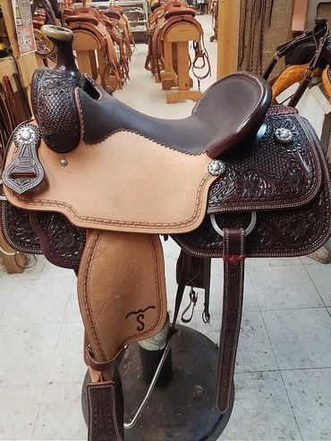 Western leather saddle with intricate designs.