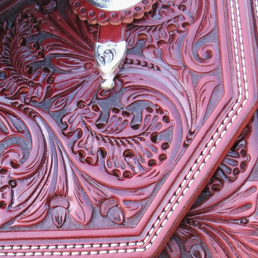 Close-up of embossed leather with floral design and stitching.