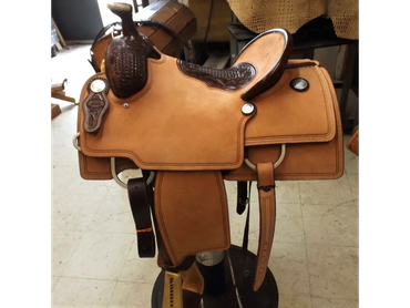 Close-up of a tan leather horse saddle.