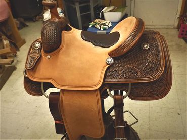 Intricately designed brown leather horse saddle.
