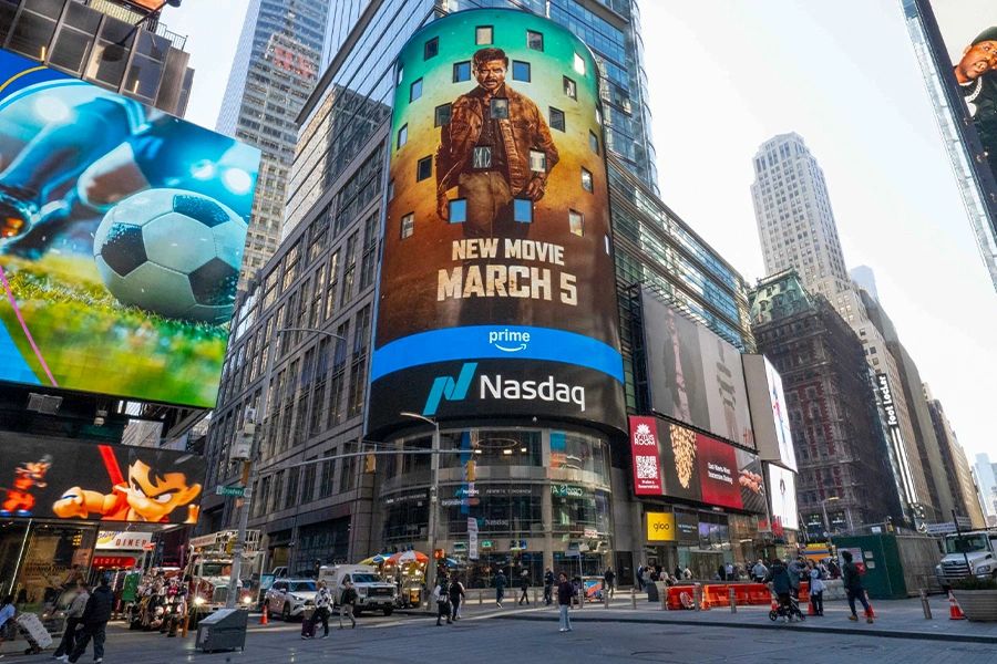 Times Square displays a new movie advertisement with Nasdaq branding.