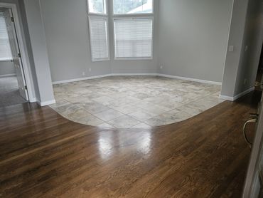 Room with curved tile and hardwood flooring transition.