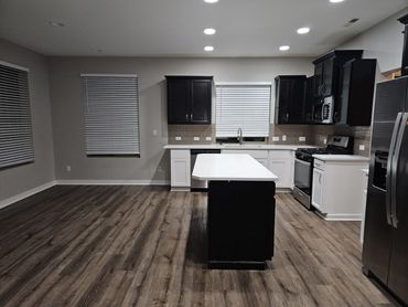 Modern kitchen with dark and white cabinets and a central island.