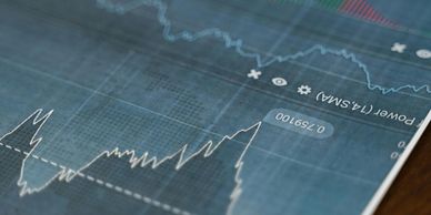 Close-up of fluctuating financial graphs on a digital screen.