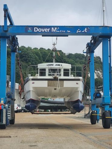 Boat named Louise Jane II being lifted at Dover Marina.