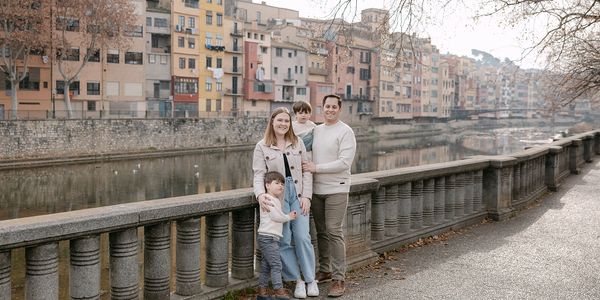 Family of four by riverside in a European town.