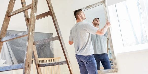 Man hanging mirror