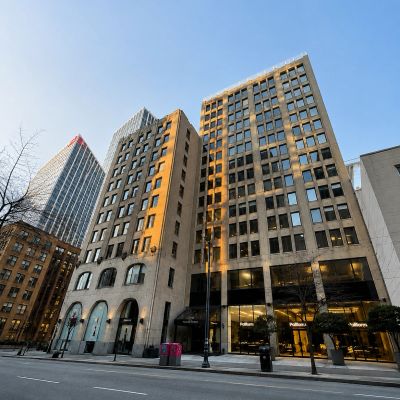 Tall modern buildings under clear sky in an urban street.