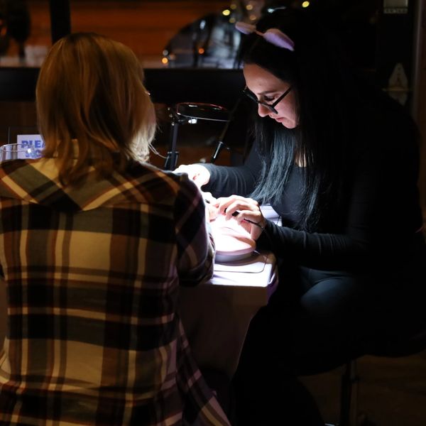 Two smiling women showing jewelry and Bolt Babes adding bracelets