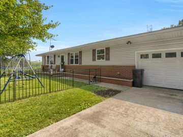Single-story house with a front yard and children's play area.