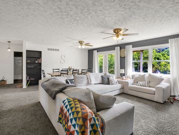 Bright living room with beige sofas and a colorful throw blanket.