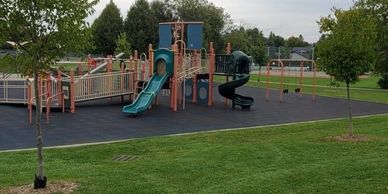 A colorful playground with slides and swings in a park.