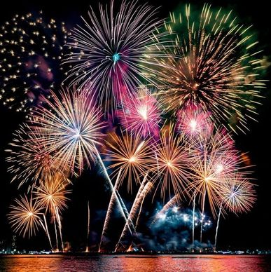 Colorful fireworks lighting up the night sky over water.