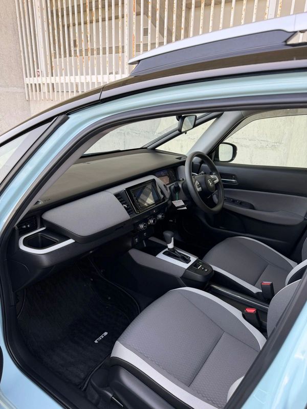 Modern car interior with gray seats and touchscreen display.