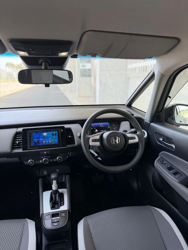 Interior of a modern Honda car showing steering wheel and dashboard.