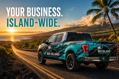 A branded pickup truck on a scenic island road at sunset.