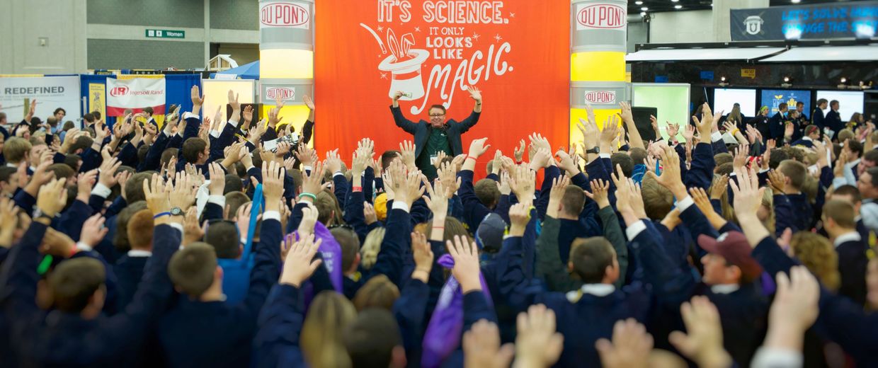 Tradeshow magician attracts large crowd to an exhibit.