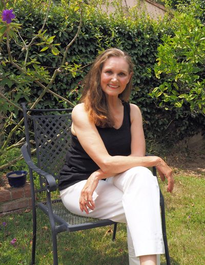 A lady sitting on the chair, smiling at the camera