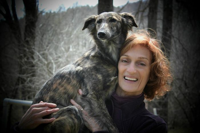 Donna holding a brindle Windsprite on her shoulder