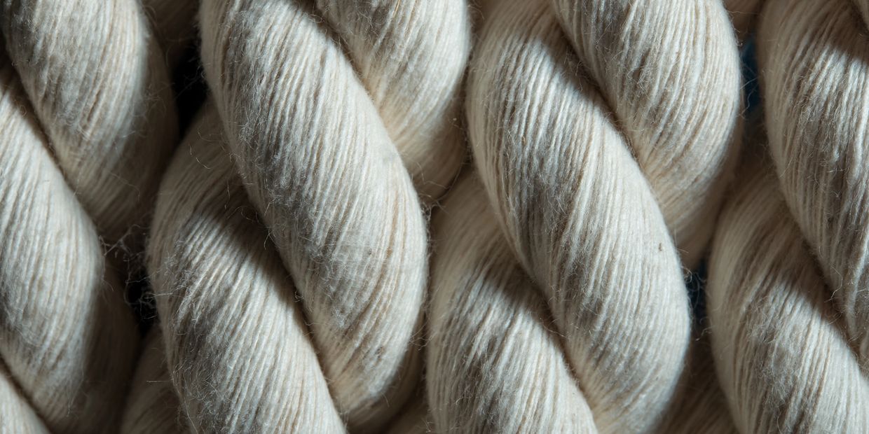Close up on a magnified picture of cream color cotton macrame cord fibers
