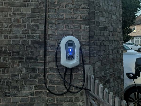 Electric vehicle charging station mounted on a brick wall.