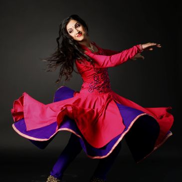 Woman spinning in colorful traditional dress.