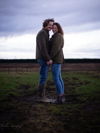 Couple holding hands face to face in rural setting.