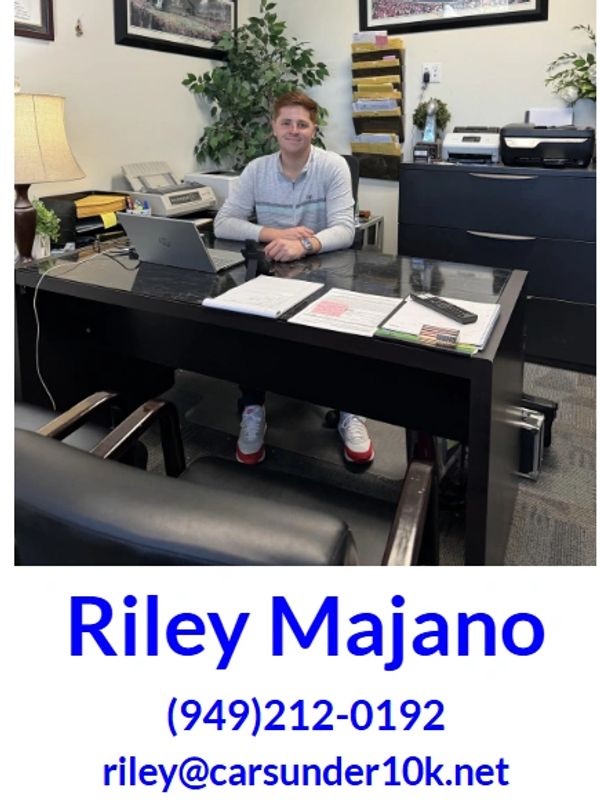 Person sitting at an office desk with contact details below.