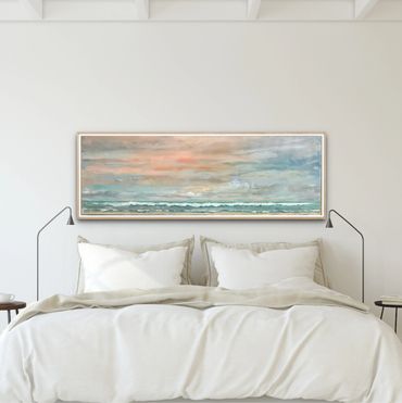 Serene beach landscape painting above a cozy white bed in a minimalist bedroom.