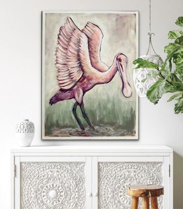 Painting of a pink spoonbill bird with wings spread, displayed above an ornate white cabinet.