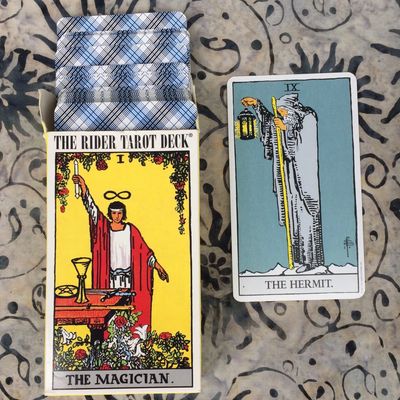 A box of Rider Waite Smith Tarot cards. The Magician is on the cover and The Hermit card next to it.
