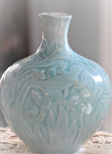 Porcelain Bottle wheel thrown & altered, water etching and carved design with Celadon glaze.